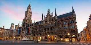 Neuschwanstein Castle-style Gothic Revival town hall with twin spires illuminated at dusk in Munich Marienplatz