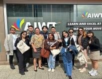 Group of diverse people posing together in front of a storefront with colorful signage